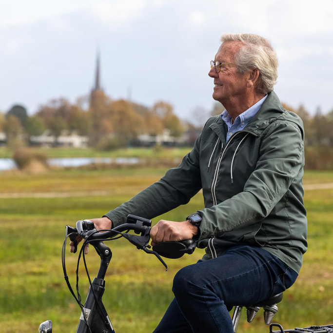 man fietst langs weilanden