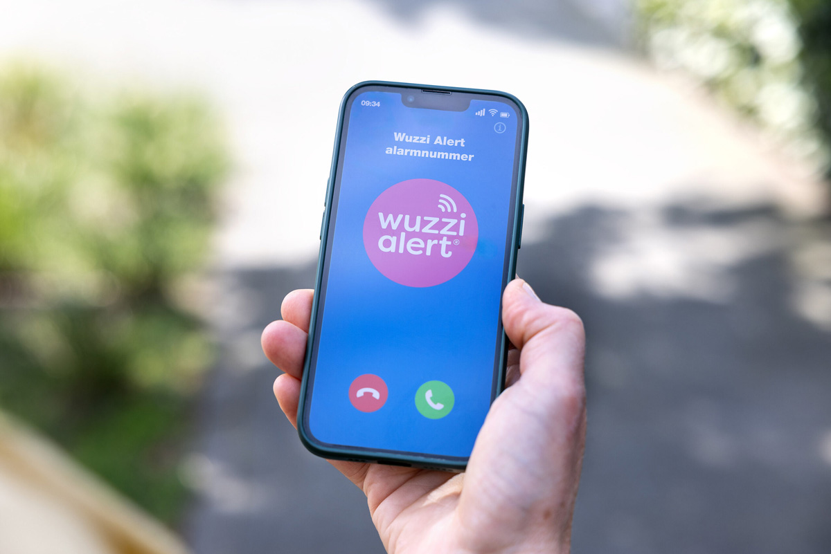 Een telefoon met een scherm met het logo van Wuzzzi Alert